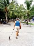 A foreign resident walks his dog on Pattaya's beach promenade.