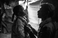 Sakina weeps over the departure of her father, who tries to comfort her. Her family lives in a tent and every day she is left alone while her parents go earn means of survival.